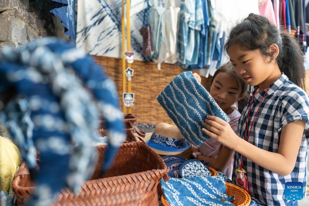 Tourists learn about tie-dye handicrafts in Bamei Village of Guangnan County, Wenshan Zhuang and Miao Autonomous Prefecture, southwest China's Yunnan Province, Aug. 25, 2025. In recent years, Bamei Village has developed local tourism utilizing its karst landscapes and cultural resources. A tourist resort which helps boost the local service sector has taken shape. (Xinhua/Gao Yongwei)