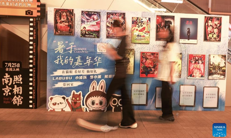 Spectators walk past movie posters at a cinema in Wuhan, central China's Hubei Province, Aug. 25, 2025. China's summer box office revenue has surpassed 11 billion yuan (about 1.5 billion U.S. dollars) as of Sunday, with homegrown titles dominating the season's top earners. (Photo by Zhao Jun/Xinhua)