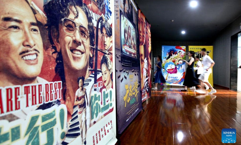 Spectators walk past movie posters at a cinema in Linyi, east China's Shandong Province, Aug. 18, 2025. China's summer box office revenue has surpassed 11 billion yuan (about 1.5 billion U.S. dollars) as of Sunday, with homegrown titles dominating the season's top earners. (Photo by Wu Jiquan/Xinhua)