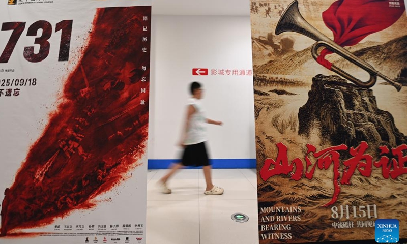 A spectator walks past movie posters at a cinema in Qingzhou, east China's Shandong Province, Aug. 17, 2025. China's summer box office revenue has surpassed 11 billion yuan (about 1.5 billion U.S. dollars) as of Sunday, with homegrown titles dominating the season's top earners. (Photo by Wang Jilin/Xinhua)