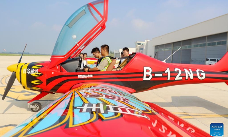A pilot instructs students to learn about the instrument panel aboard an aircraft at a general aviation industrial park in Laixi, Qingdao, east China's Shandong Province, Aug. 24, 2025. Laixi City has made efforts in promoting general aviation industry, including establishing a professional industrial park, introducing airplane manufacture companies and developing flight training business, which have activated the vitality of low-altitude economy. (Photo: Xinhua)