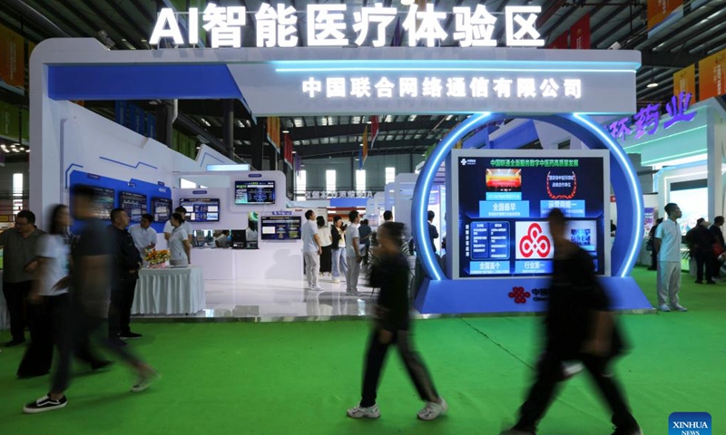 Visitors walk past the area of AI-powered traditional Chinese medicine (TCM) healthcare during the 6th China (Gansu) TCM Industry Expo in Longxi County of Dingxi City, northwest China's Gansu Province, Aug. 24, 2025. The expo opened here on Sunday. (Photo: Xinhua)