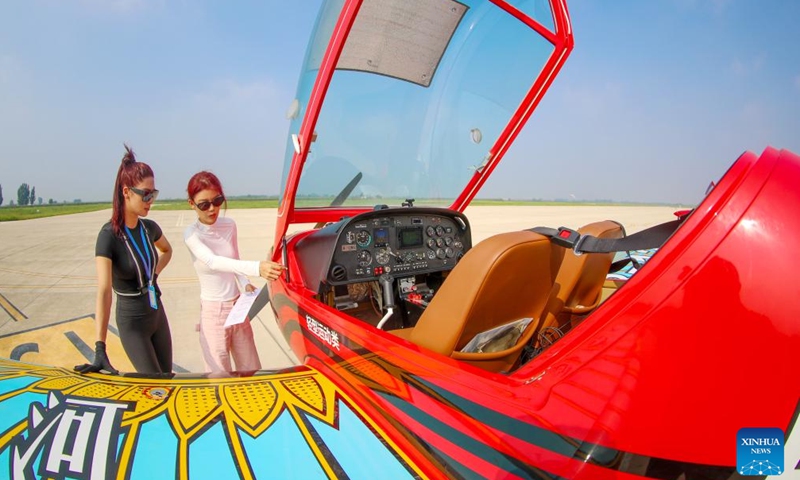 An instructor (R) checks the aircraft with a trainee before the flight at a general aviation industrial park in Laixi, Qingdao, east China's Shandong Province, Aug. 24, 2025. Laixi City has made efforts in promoting general aviation industry, including establishing a professional industrial park, introducing airplane manufacture companies and developing flight training business, which have activated the vitality of low-altitude economy. (Photo: Xinhua)
