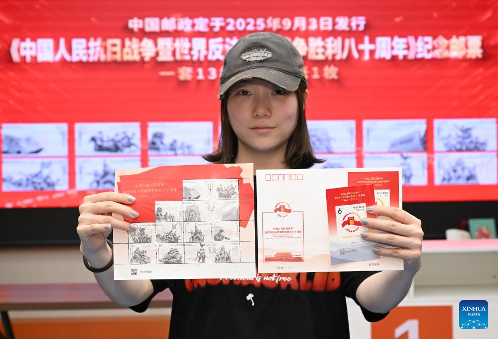 A citizen shows the commemorative stamps issued by China Post to mark the 80th anniversary of the victory in the Chinese People's War of Resistance Against Japanese Aggression and the World Anti-Fascist War at a stamp company in Beijing, capital of China, Sept. 3, 2025. A total of six million stamp sets were issued, with each set containing 13 stamps. Five million miniature sheets were also issued. (Xinhua/Li He)