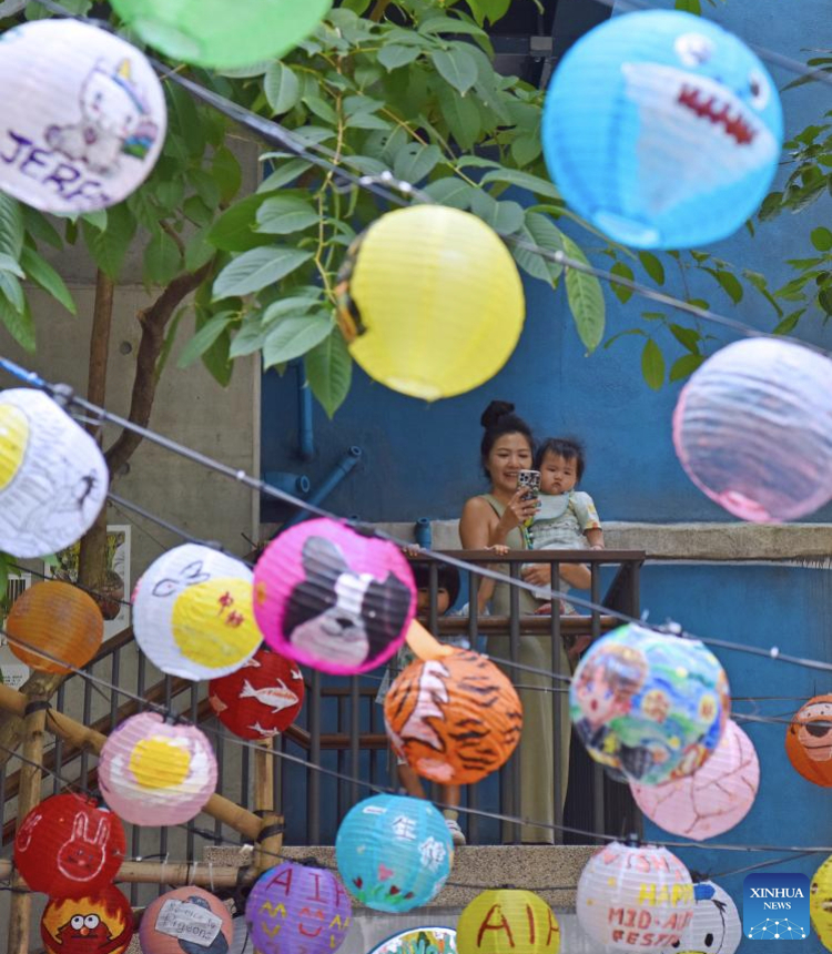 A mother and her child view decorative lanterns in south China's Hong Kong, Sept. 28, 2025. With the approach of National Day and the Mid-Autumn Festival, the streets of Hong Kong are adorned with festive decorations. (Xinhua/Chen Duo)