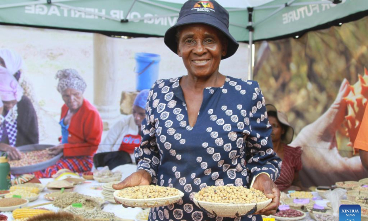 A farmer shows her agricultural products at a seed and food festival in Harare, Zimbabwe, Sept. 20, 2025. TO GO WITH Feature: Farmers embrace indigenous seeds to strengthen food security in Zimbabwe (Xinhua/Tafara Mugwara)