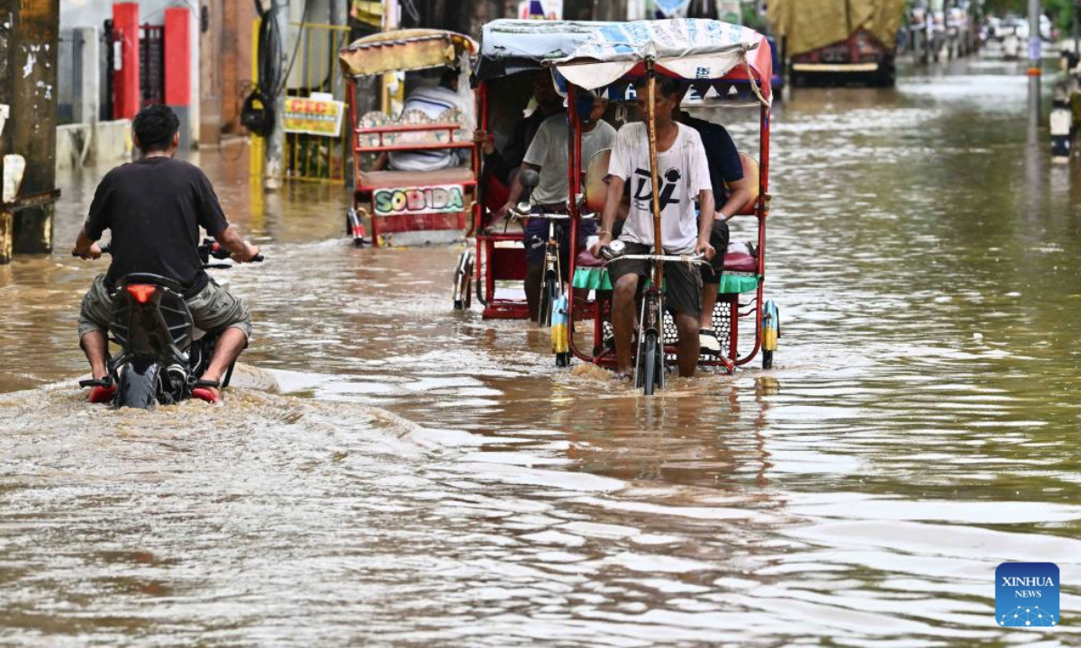 Residents commute on cycle rickshaws through floodwaters after heavy monsoon rain in Guwahati city of India's northeastern state of Assam, Sept. 16, 2025. (Str/Xinhua)