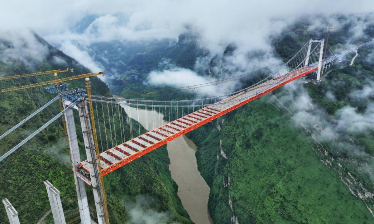 An aerial drone photo taken on Sept. 23, 2025 shows the Tianmen grand bridge under construction in southwest China's Guizhou Province. The Tianmen grand bridge on the Anshun-Panzhou highway, with a length of 1,553 meters and the bridge floor hung about 560 meters above the canyon water, finished its closure on Tuesday. (Xinhua/Liu Xu)