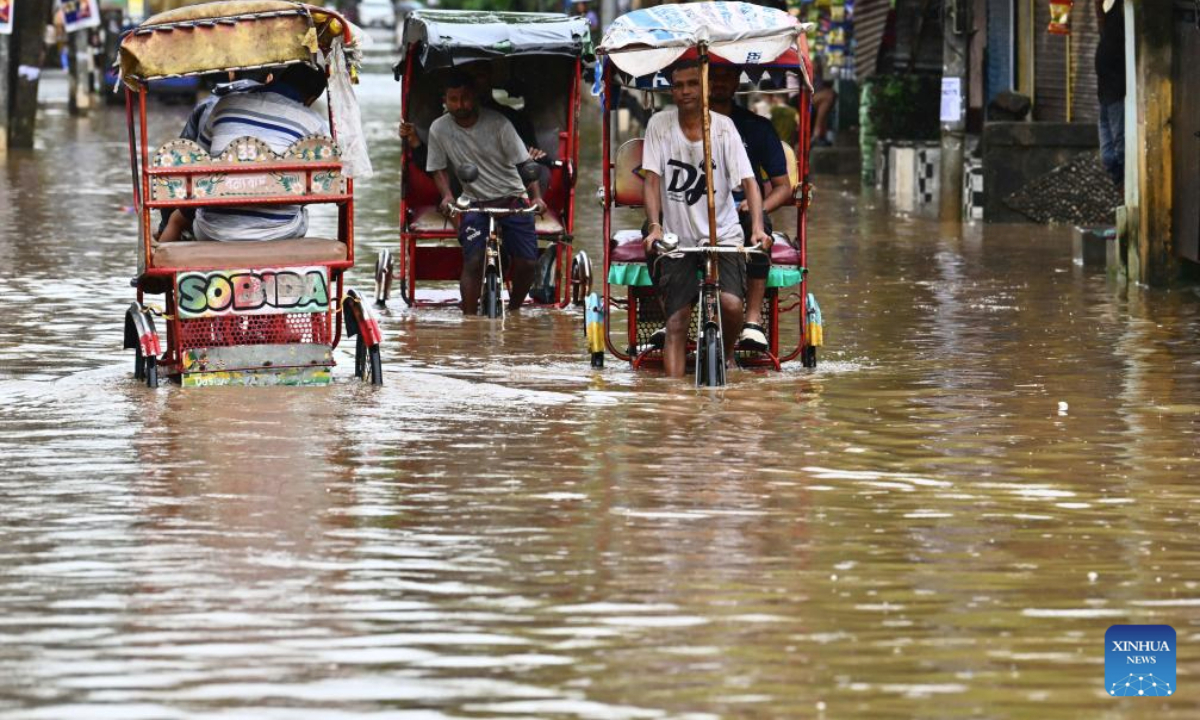 Residents commute on cycle rickshaws through floodwaters after heavy monsoon rain in Guwahati city of India's northeastern state of Assam, Sept. 16, 2025. (Str/Xinhua)