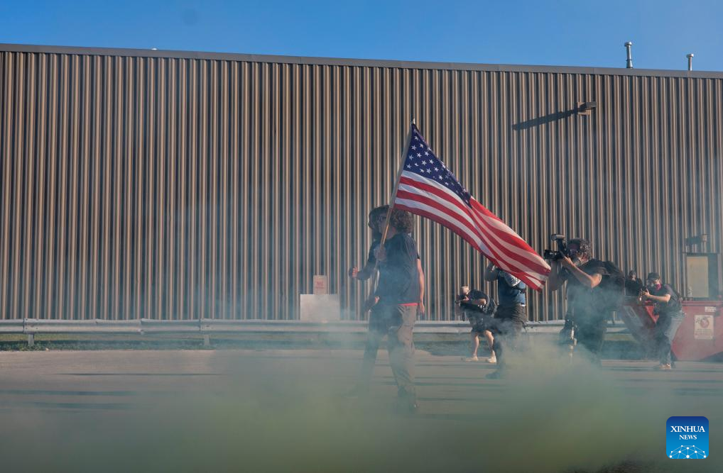 A pair of protesters confront with the Immigration and Customs Enforcement (ICE) officers outside a ICE facility in Broadview in the western suburbs of Chicago, the United States, on Sept. 26, 2025. (Photo by Vincent D. Johnson/Xinhua)