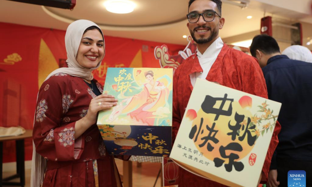 Workers pose for photos during a Mid-Autumn Festival celebration at the Central Business District (CBD) in the New Administrative Capital, east of Cairo, Egypt, on Sept. 28, 2025. The Egyptian branch of China State Construction Engineering Corporation (CSCEC) on Sunday held an event to celebrate the upcoming traditional Chinese Mid-Autumn Festival at the CSCEC-built CBD, where CSCEC's workers from China and Egypt experience rich festival cultures, such as the making of traditional Chinese lanterns and moon cakes. (Xinhua/Sui Xiankai)