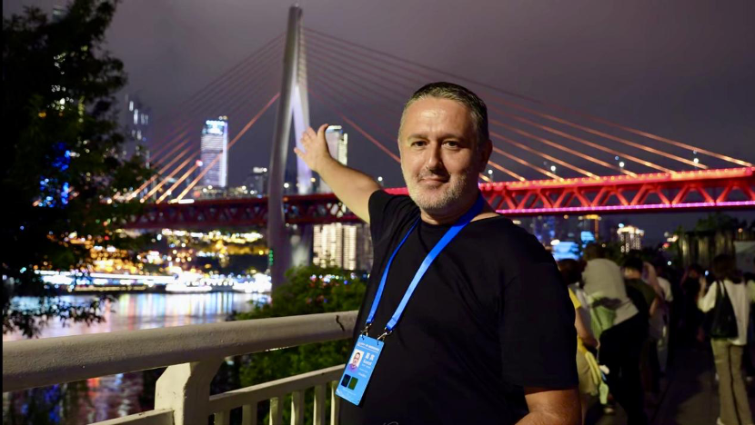 Branko Zujovic poses in front of Chongqing Qiansimen Jialing River Bridge, Chongqing, September 22, 2025. (Photo: People's Daily/Li Yidan)