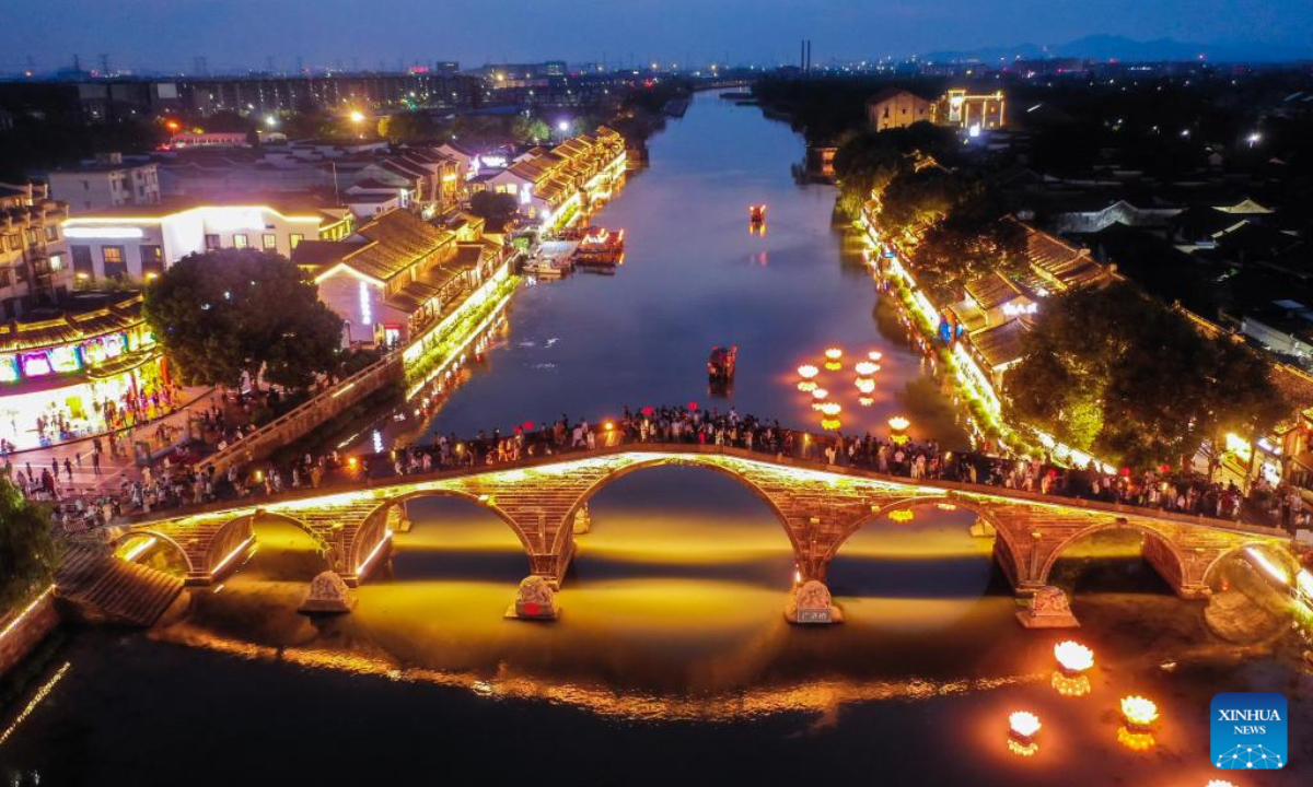 An aerial drone photo shows tourists visiting Tangqi ancient town in Hangzhou, east China's Zhejiang Province, Oct. 2, 2025. The town offers tourists night boat tours and dazzling lanterns during the eight-day National Day and Mid-Autumn Festival holiday that began on Wednesday. (Xinhua/Xu Yu)