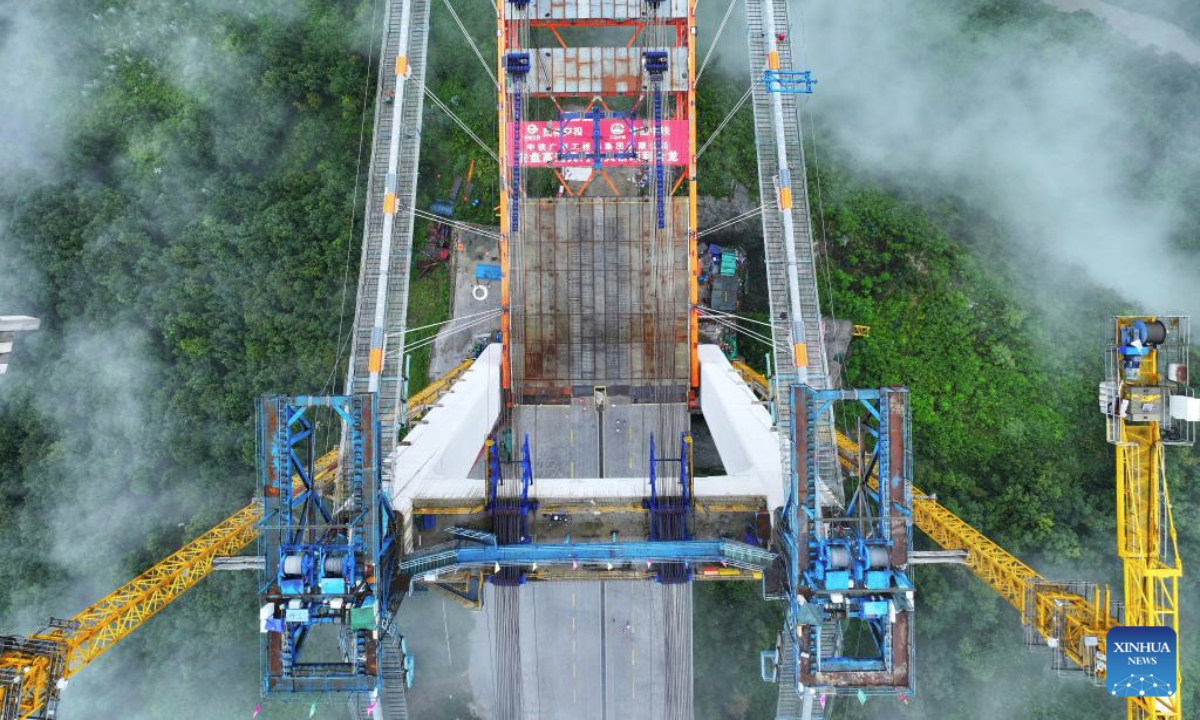 An aerial drone photo taken on Sept. 23, 2025 shows the Tianmen grand bridge under construction in southwest China's Guizhou Province. The Tianmen grand bridge on the Anshun-Panzhou highway, with a length of 1,553 meters and the bridge floor hung about 560 meters above the canyon water, finished its closure on Tuesday. (Xinhua/Liu Xu)