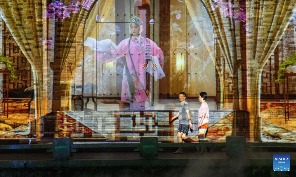Residents stroll along the ancient canal in Wuxi City, east China's Jiangsu Province, Sept. 23, 2025. The Qingming bridge historical and cultural community spreads across the ancient canal, and boasts rich heritages. It is attracting an increasing number of visitors as more modern technologies have been adopted for enhanced sensory experiences. (Xinhua/Hu Zhixuan)