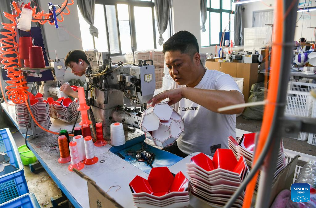 Workers make footballs at a local sports goods company in Yiwu, east China's Zhejiang Province, Sept. 15, 2025. China's Yiwu, dubbed the world's supermarket, has recently witnessed a surge in orders for sports products, driven by major sporting events including the upcoming 2026 FIFA World Cup. (Photo by Shi Kuanbing/Xinhua)