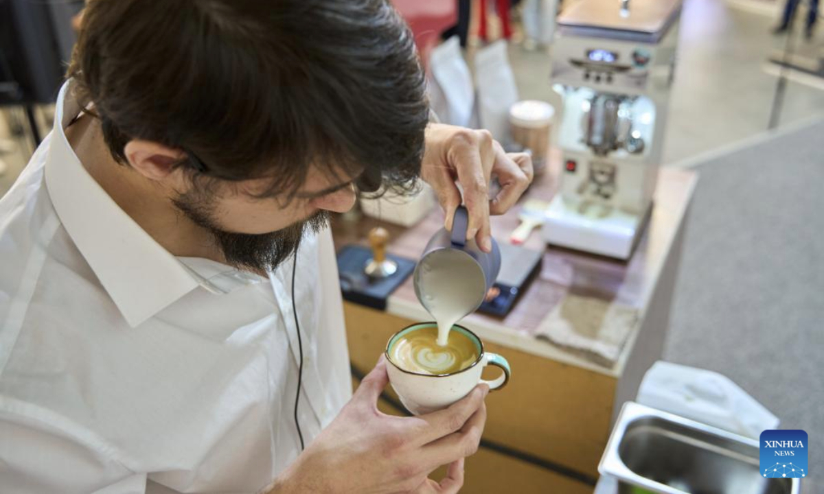 A barista makes latte art during the Far Eastern Tea and Coffee Championship in Vladivostok, Russia, Oct. 9, 2025. The event was held here on Thursday, drawing 12 baristas to compete by showcasing their skills in making espresso and latte drinks. (Photo by Guo Feizhou/Xinhua)