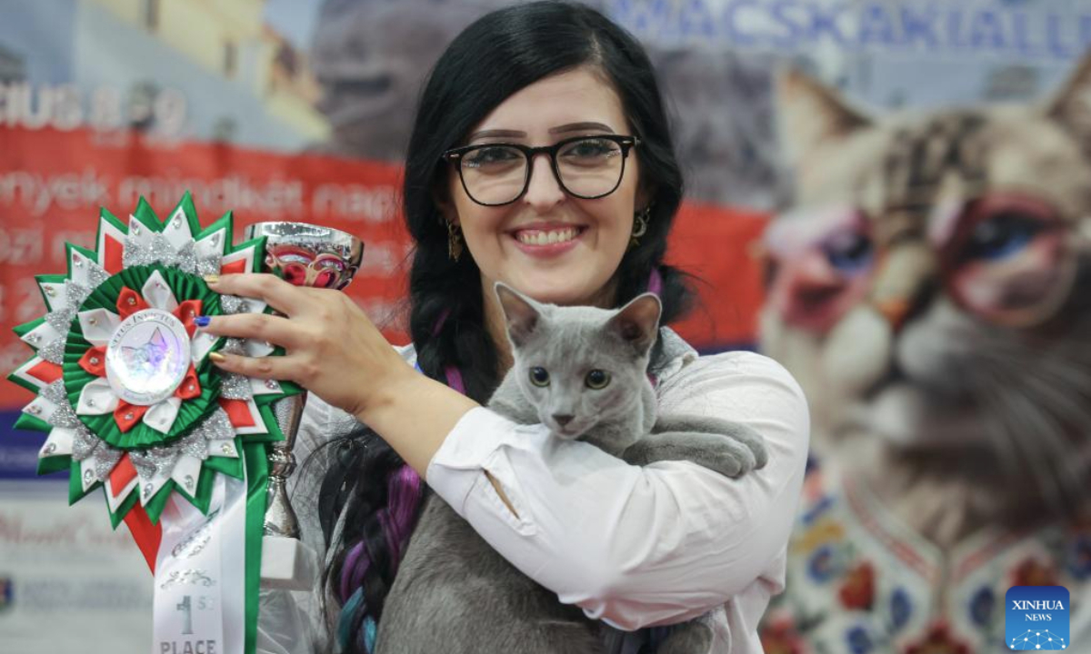 An owner shows her award during the World Cat Federation (WCF) cat show in Budapest, Hungary on Sept. 28, 2025. (Photo by Attila Volgyi/Xinhua)