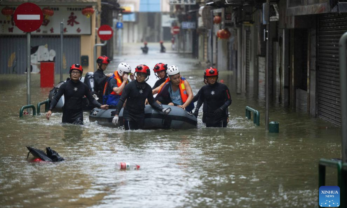 Staff members from the local customs authority help stranded citizens to evacuate on an inundated street in Macao, south China, Sept. 24, 2025. Super typhoon Ragasa passed within 100 km of the Macao Special Administrative Region (SAR) on Wednesday morning, causing gale and heavy rain, said Macao's meteorological bureau, which hoisted the No. 10 tropical cyclone signal at 5:30 a.m. local time. (Xinhua/Cheong Kam Ka)