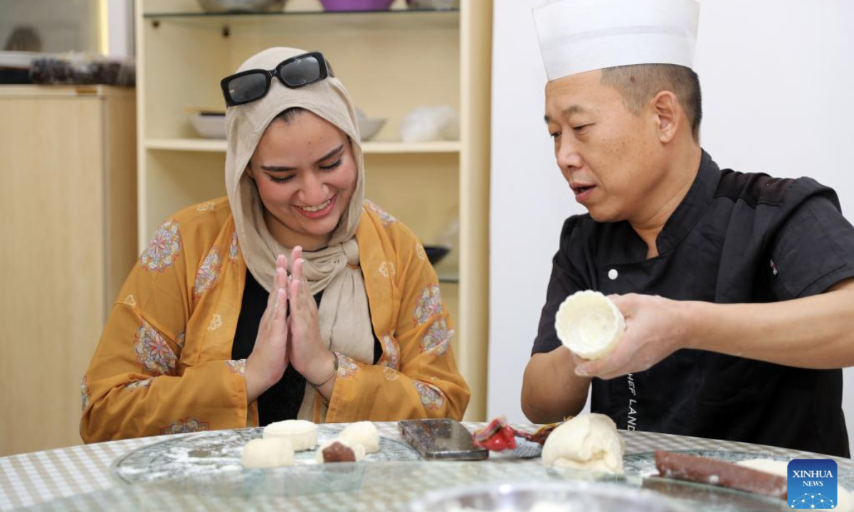 A worker learns to make moon cakes during a Mid-Autumn Festival celebration at the Central Business District (CBD) in the New Administrative Capital, east of Cairo, Egypt, on Sept. 28, 2025. The Egyptian branch of China State Construction Engineering Corporation (CSCEC) on Sunday held an event to celebrate the upcoming traditional Chinese Mid-Autumn Festival at the CSCEC-built CBD, where CSCEC's workers from China and Egypt experience rich festival cultures, such as the making of traditional Chinese lanterns and moon cakes. (Xinhua/Sui Xiankai)
