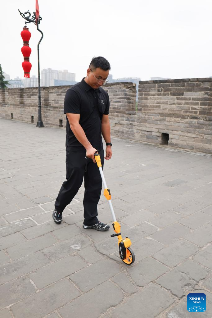 An inspector measures the length of a crack on the ancient city wall in Xi'an, northwest China's Shaanxi Province, Sept. 10, 2025. The 13.74-kilometer-long ancient city wall that surrounds Xi'an is one of the longest and best-preserved of its kind in China. A digital comprehensive management platform has been built for the wall since 2023, which integrates functions such as cultural relic protection, cultural tourism operation, emergency management, and flood-control command.
By comprehensively applying advanced technologies including big data analysis, Internet of Things, etc., the platform provides a digital and intelligent foundation for the protection of this historic city. (Xinhua/Zhu Weixi)