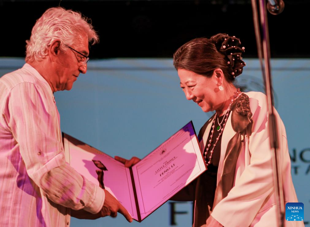 Chinese artist Feng Li (R) receives the Little Prince Lifetime Achievement Award at the 32nd International Festival of Children's Theatres in Subotica, Serbia, on Sept. 21, 2025. Feng Li became the first Chinese laureate of the festival's highest honor. (China National Opera and Dance Drama Theatre/Handout via Xinhua)
