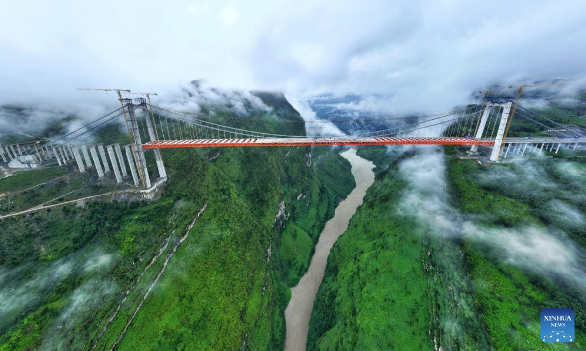 An aerial drone photo taken on Sept. 23, 2025 shows the Tianmen grand bridge under construction in southwest China's Guizhou Province. The Tianmen grand bridge on the Anshun-Panzhou highway, with a length of 1,553 meters and the bridge floor hung about 560 meters above the canyon water, finished its closure on Tuesday. (Xinhua/Liu Xu)