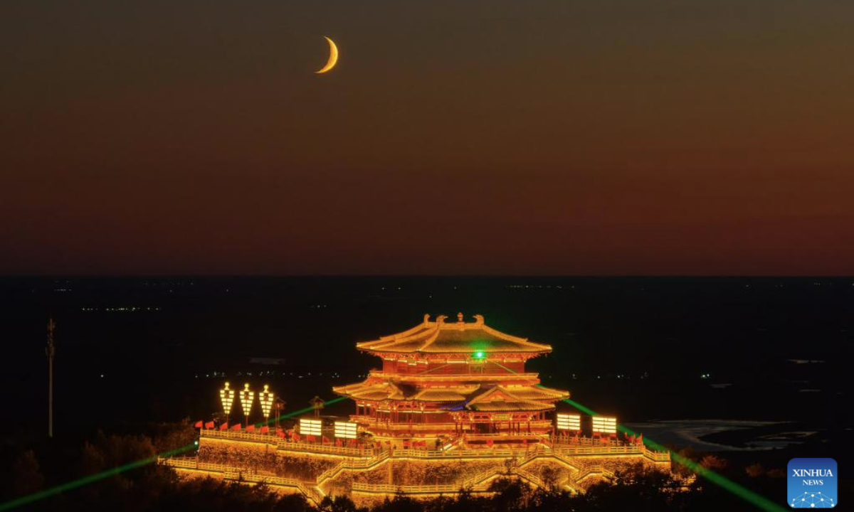 An aerial drone photo shows a view of the Dongji Pavilion and a crescent moon in the sky over Fuyuan, Jiamusi City of northeast China's Heilongjiang Province, Sept. 26, 2025. (Photo by Li Yongjun/Xinhua)