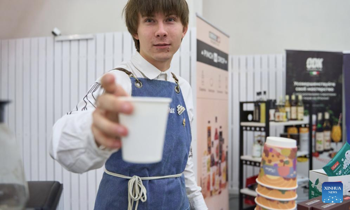 A barista makes coffee for a visitor during the Far Eastern Tea and Coffee Championship in Vladivostok, Russia, Oct. 9, 2025. The event was held here on Thursday, drawing 12 baristas to compete by showcasing their skills in making espresso and latte drinks. (Photo by Guo Feizhou/Xinhua)