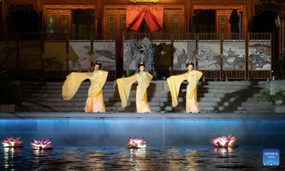 Artists perform along the ancient canal in Wuxi City, east China's Jiangsu Province, Sept. 23, 2025. The Qingming bridge historical and cultural community spreads across the ancient canal, and boasts rich heritages. It is attracting an increasing number of visitors as more modern technologies have been adopted for enhanced sensory experiences. (Xinhua/Hu Zhixuan)