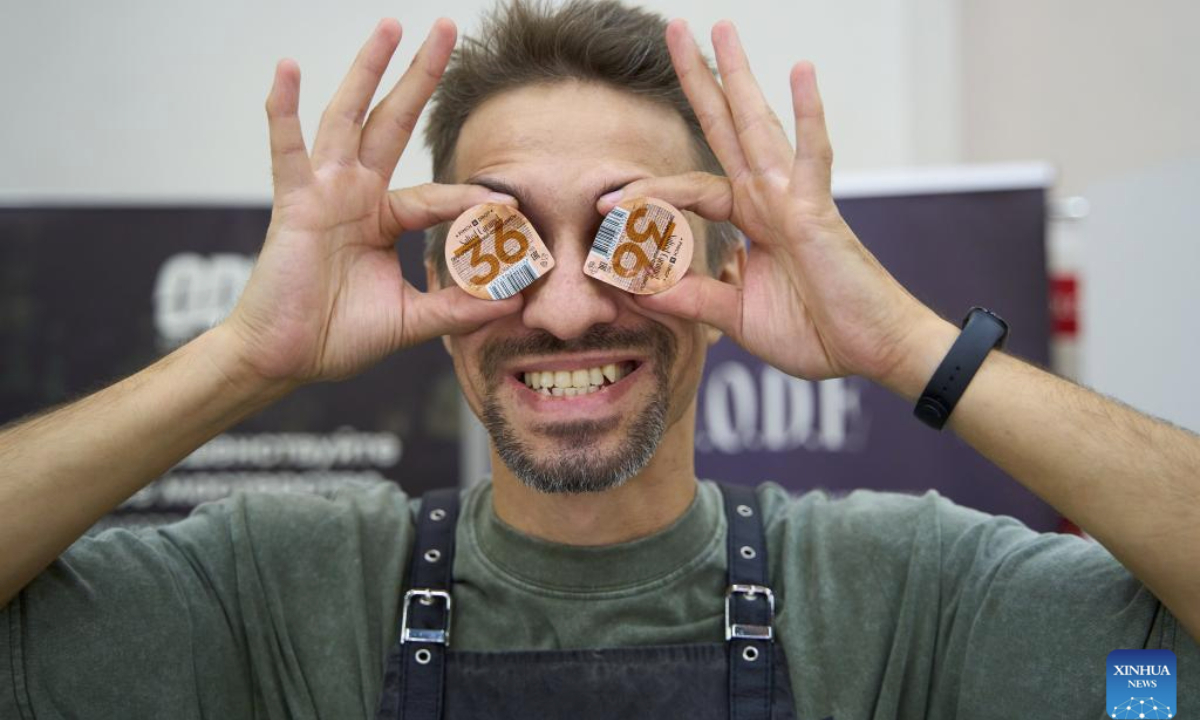 A staff member shows coffee syrup during the Far Eastern Tea and Coffee Championship in Vladivostok, Russia, Oct. 9, 2025. The event was held here on Thursday, drawing 12 baristas to compete by showcasing their skills in making espresso and latte drinks. (Photo by Guo Feizhou/Xinhua)