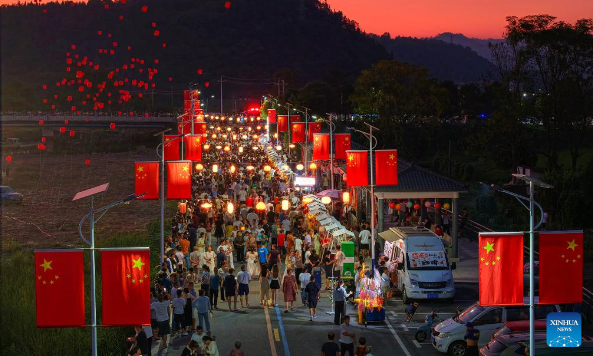 A drone photo taken on Oct. 6, 2025 shows people visiting Shitang Town of Qianshan County in Shangrao, east China's Jiangxi Province. Tourists across the country show no sign of fading enthusiasm as the National Day and Mid-Autumn Festival holiday draws to a close. (Photo by Ding Minghua/Xinhua)