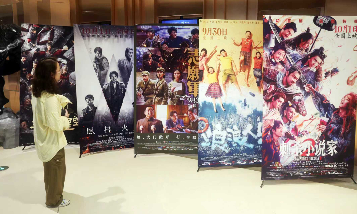 A moviegoer looks at posters for newly released National Day holiday films in Shanghai. Photo: VCG