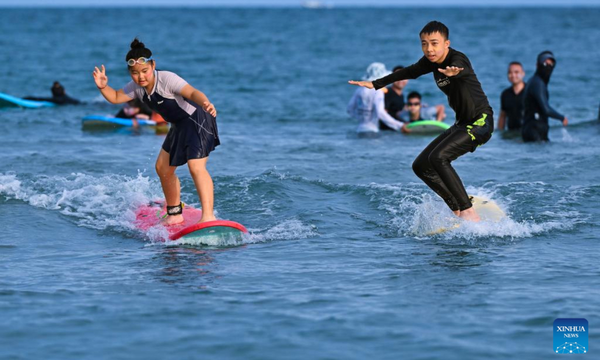 Tourists surf at Riyue Bay in Wanning, south China's Hainan Province, Oct. 2, 2025. Surfing has become a symbol of Wanning thanks to its unique geographical and climatic advantages. (Xinhua/Guo Cheng)