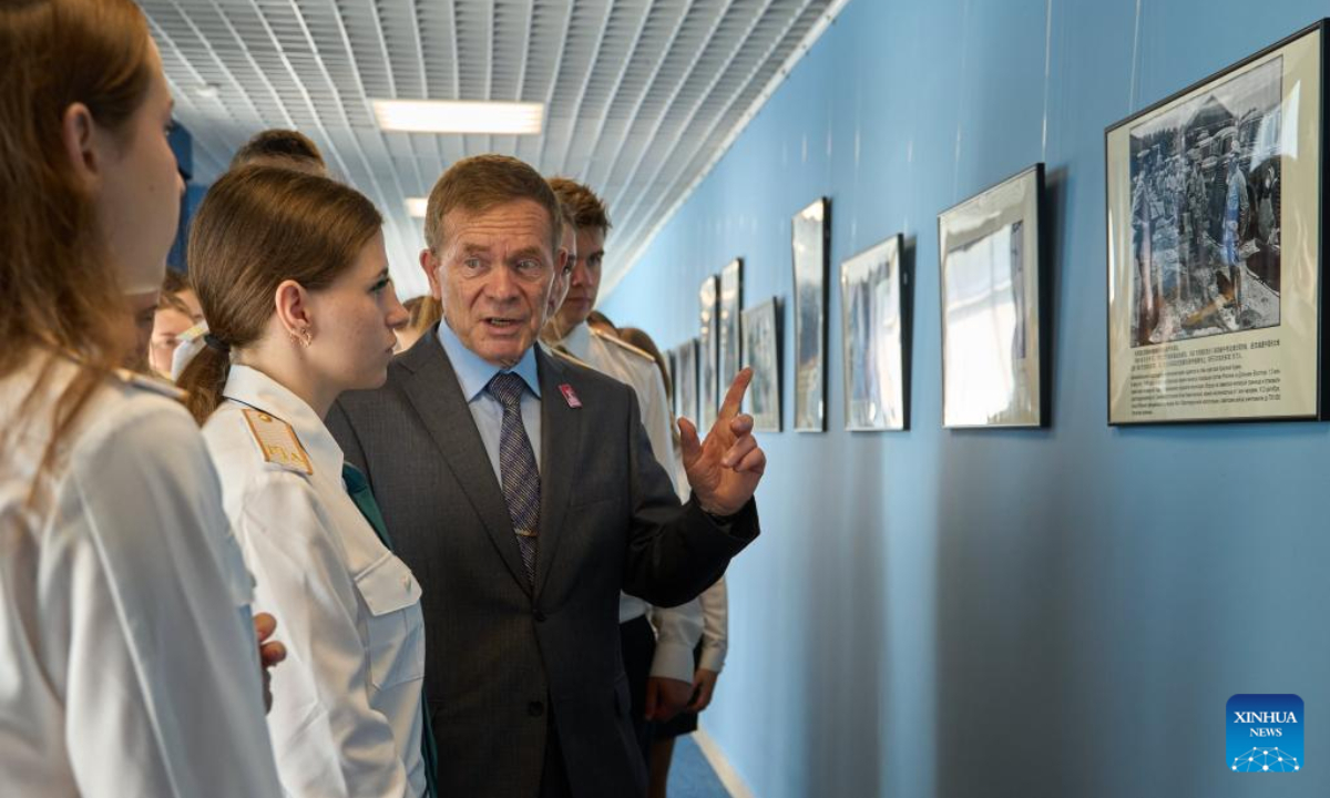 A teacher introduces a photo to students at a photo exhibition commemorating the 80th anniversary of the victory in the Chinese People's War of Resistance against Japanese Aggression and the World Anti-Fascist War in Vladivostok, Russia, Sept. 2, 2025. (Photo by Guo Feizhou/Xinhua)