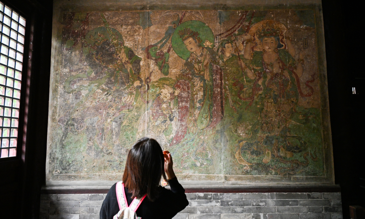 A tourist visits Longxing Temple, taking a look at an ancient mural, in Shijiazhuang, North China’s Hebei Province, on August 24, 2025. Photo: VCG