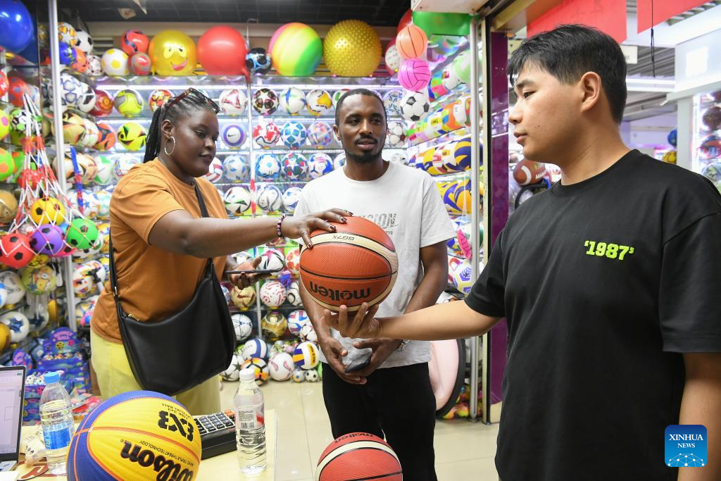 Foreign clients negotiate with a ball product dealer at Yiwu International Trade City in Yiwu, east China's Zhejiang Province, Sept. 15, 2025. China's Yiwu, dubbed the world's supermarket, has recently witnessed a surge in orders for sports products, driven by major sporting events including the upcoming 2026 FIFA World Cup. (Photo by Shi Kuanbing/Xinhua)