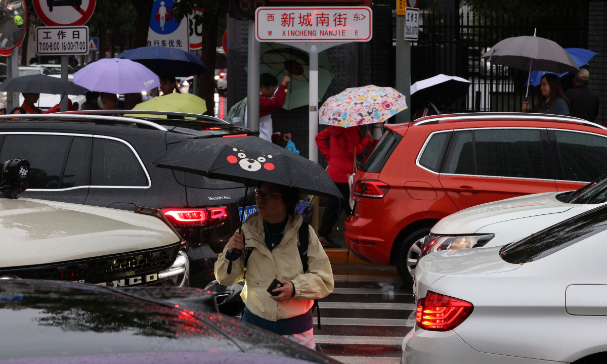 Residents in Tongzhou district, Beijing rush to work and school in the rain as continuous rainfall worsened the traffic congestion during the morning rush hour after the National Day holidays on October 9, 2025. Photo: IC