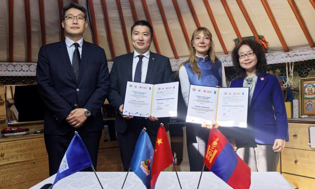 Delegates pose for photos with signed contracts during a signing ceremony for a China-funded project under the Global Development and South-South Cooperation Fund (GDSSCF) in Ulan Bator, Mongolia, on Sept. 25, 2025. The event was held here on Thursday, marking the launch of a major initiative to upgrade the city's slum areas, known as ger districts, through solar photovoltaic systems. (Xinhua/Bolortsetseg)