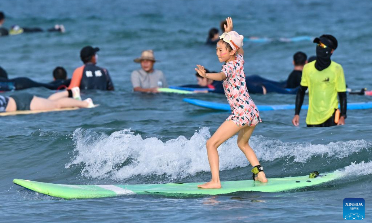 A girl surfs at Riyue Bay in Wanning, south China's Hainan Province, Oct. 2, 2025. Surfing has become a symbol of Wanning thanks to its unique geographical and climatic advantages. (Xinhua/Guo Cheng)