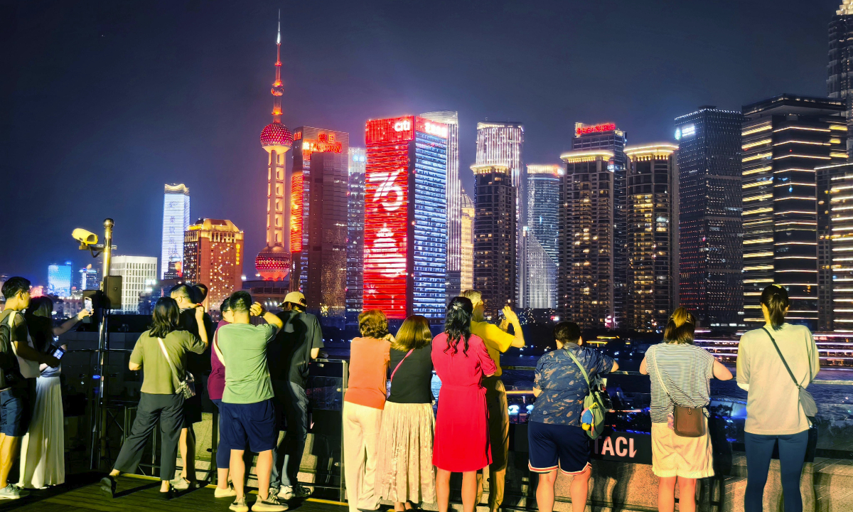 Tourists watch the night light show of the Lujiazui skyline in Shanghai on October 1, 2025. Photo： VCG