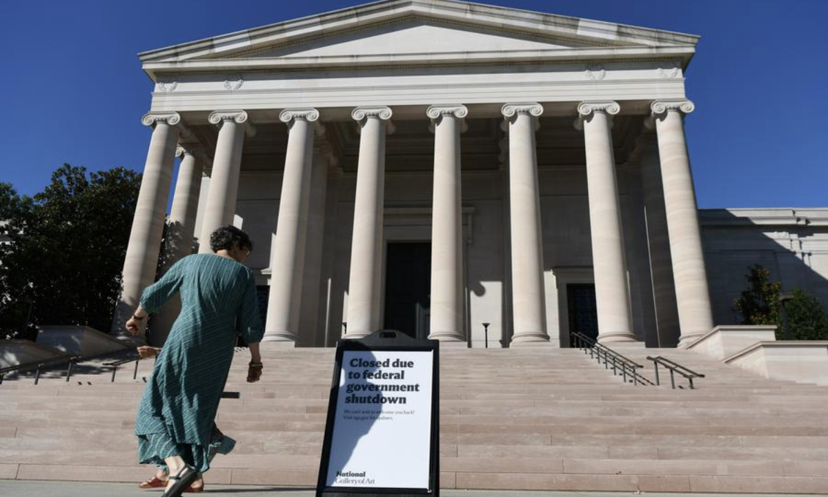 A woman walks past a notice of closure of the National Gallery of Art in Washington, D.C., the United States, Oct. 5, 2025. (Xinhua/Li Rui)