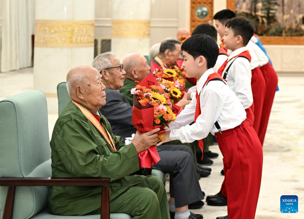 Members of the Chinese Young Pioneers present flowers to war veterans before a grand cultural gala at the Great Hall of the People in Beijing, capital of China, Sept. 3, 2025. The grand cultural gala with the theme of Justice Prevails was staged here to commemorate the 80th anniversary of the victory of the Chinese People's War of Resistance against Japanese Aggression and the World Anti-Fascist War. (Xinhua/Li Xiang)