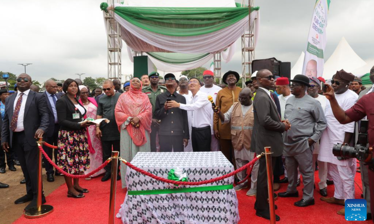 Nyesom Wike (C), minister of Nigeria's Federal Capital Territory Administration (FCTA), lights up a sample solar streetlight during the launch ceremony of the