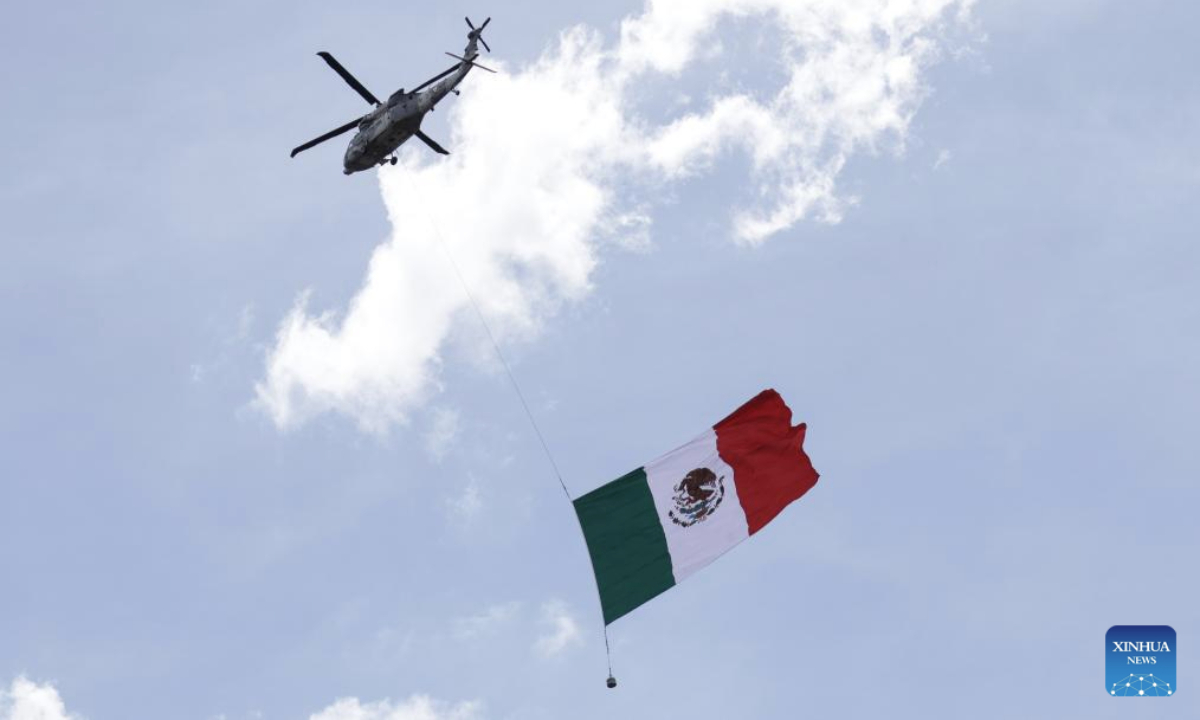 A military helicopter carrying the Mexican flag flies over the Zocalo Square during an Independence Day military parade in Mexico City, Mexico, Sept. 16, 2025. (Photo by Francisco Canedo/Xinhua)