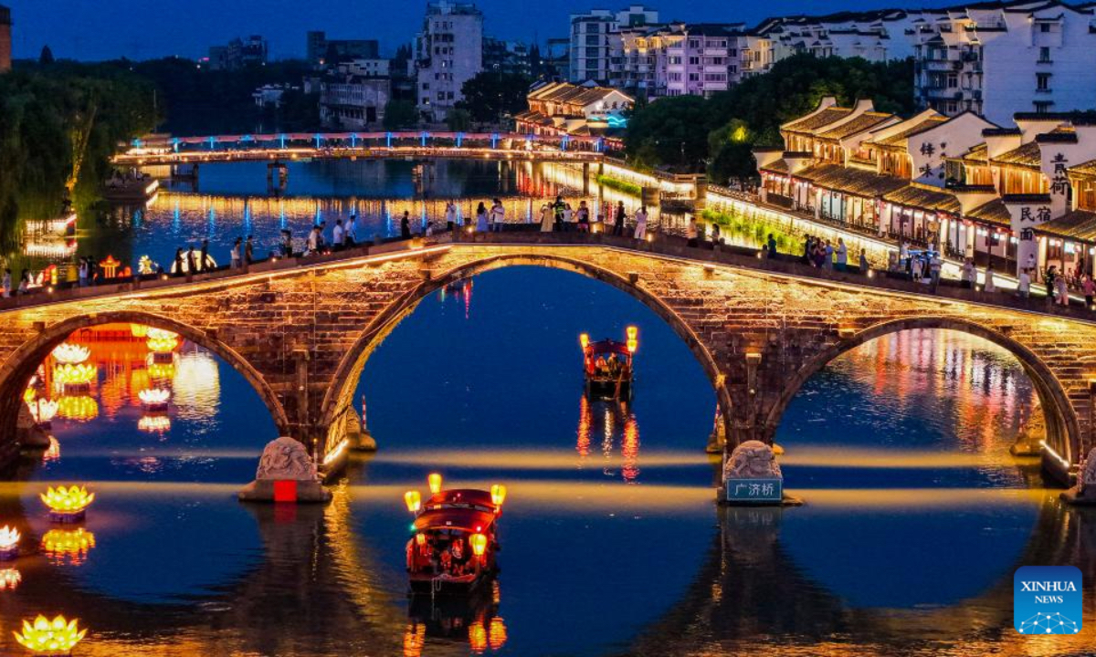 A drone photo shows tourists visiting Tangqi ancient town in Hangzhou, east China's Zhejiang Province, Oct. 2, 2025. The town offers tourists night boat tours and dazzling lanterns during the eight-day National Day and Mid-Autumn Festival holiday that began on Wednesday. (Xinhua/Xu Yu)