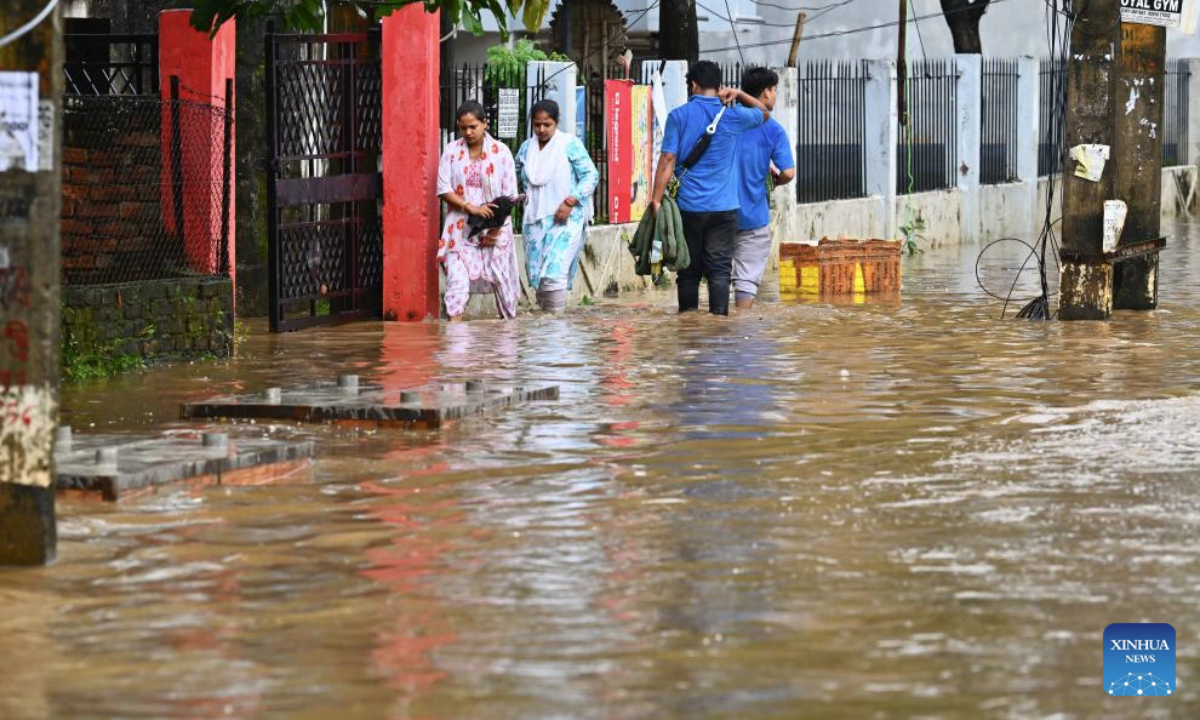 Residents wade through a flooded street after heavy rainfall in Guwahati city of India's northeastern state of Assam, Sept. 16, 2025. (Str/Xinhua)