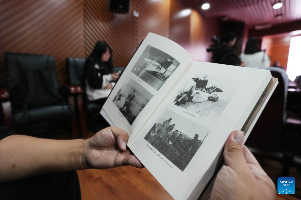 A reader reads a book on the crimes of Unit 731 during a launch ceremony held at the Exhibition Hall of Evidence of Crimes Committed by Unit 731 of the Japanese Imperial Army, in Harbin, northeast China's Heilongjiang Province, Sept. 17, 2025. The two books, with the latest research covering transnational verification, oral histories, and multilingual archives, record the crimes of Unit 731 and expose Japan's wartime atrocities. (Xinhua/Wang Song)