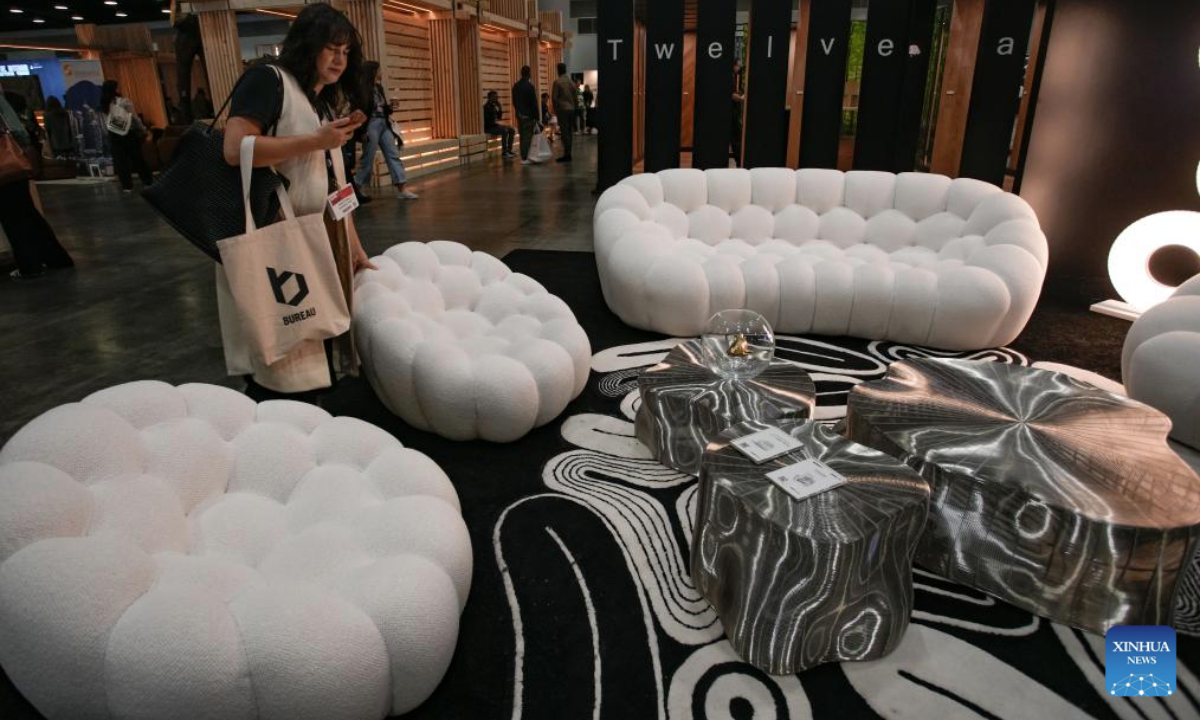 A woman learns about furniture designs during the Interior Design Show in Vancouver, British Columbia, Canada, Sept. 26, 2025. The annual show is held here from Sept. 25 to 28. (Photo by Liang Sen/Xinhua)