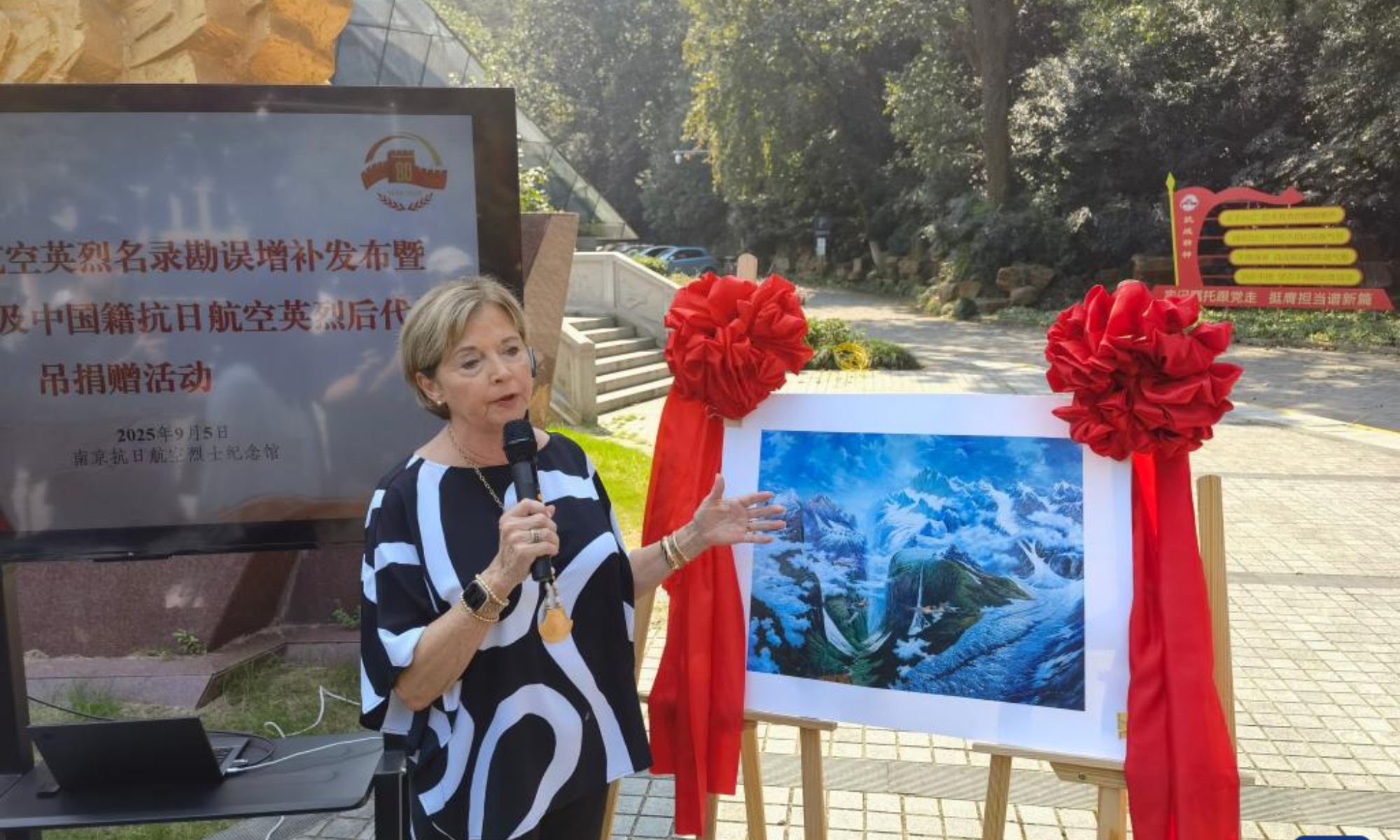 This mobile phone photo taken on Sept. 5, 2025 shows Nell Chennault Calloway, granddaughter of Claire Lee Chennault, introducing a donated oil painting at the Nanjing Anti-Japanese Aviation Martyrs Memorial Hall in east China's Jiangsu Province, Sept. 5, 2025. (Xinhua/Qiu Bingqing)